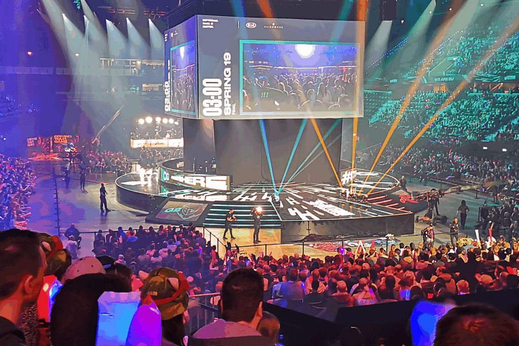 A crowd gathers to watch a League of Legends video on a large screen during the Roadshow event in Paris.
