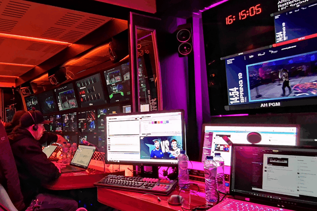 A busy OB Van during the League of Legends Roadshow in Paris, featuring people working on computers with several monitors.