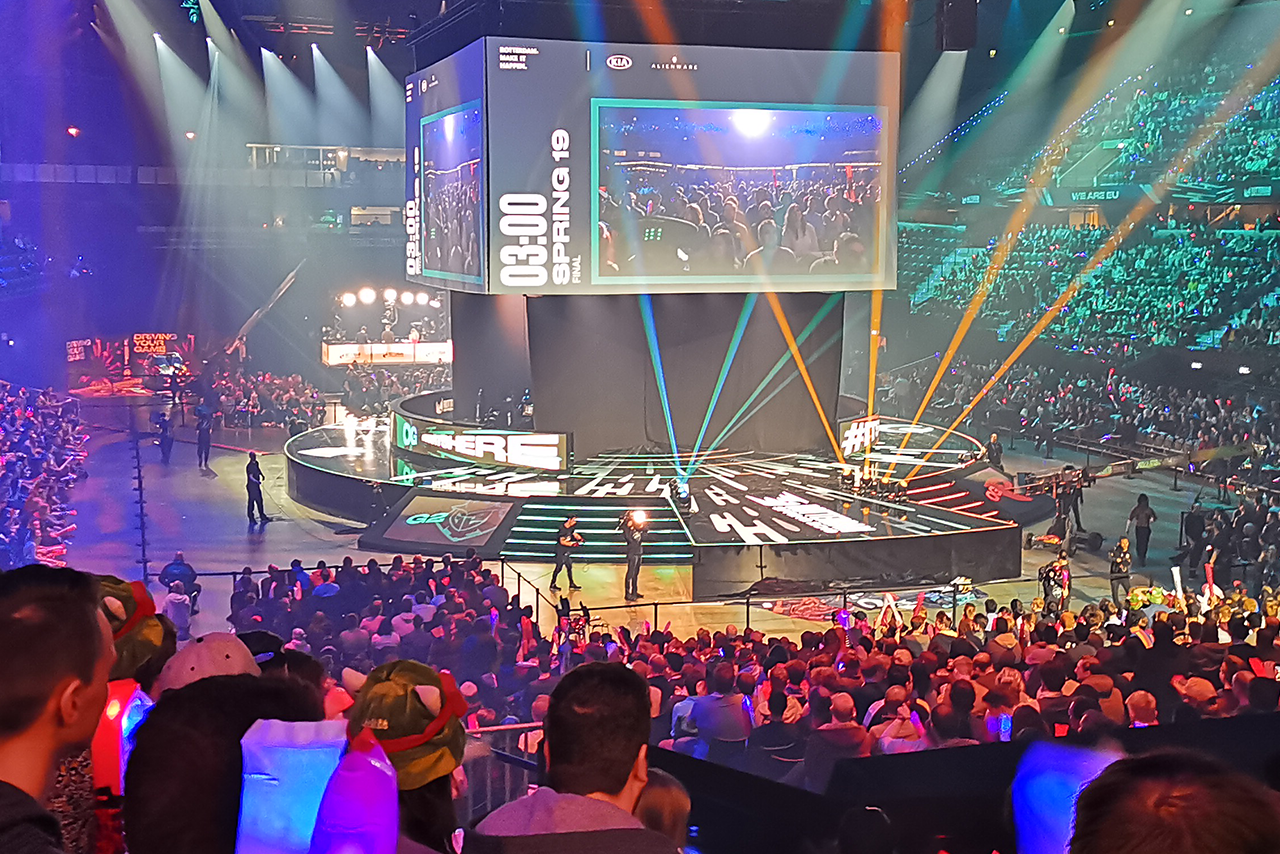 A crowd gathers to watch a League of Legends video on a large screen during the Roadshow event in Paris.