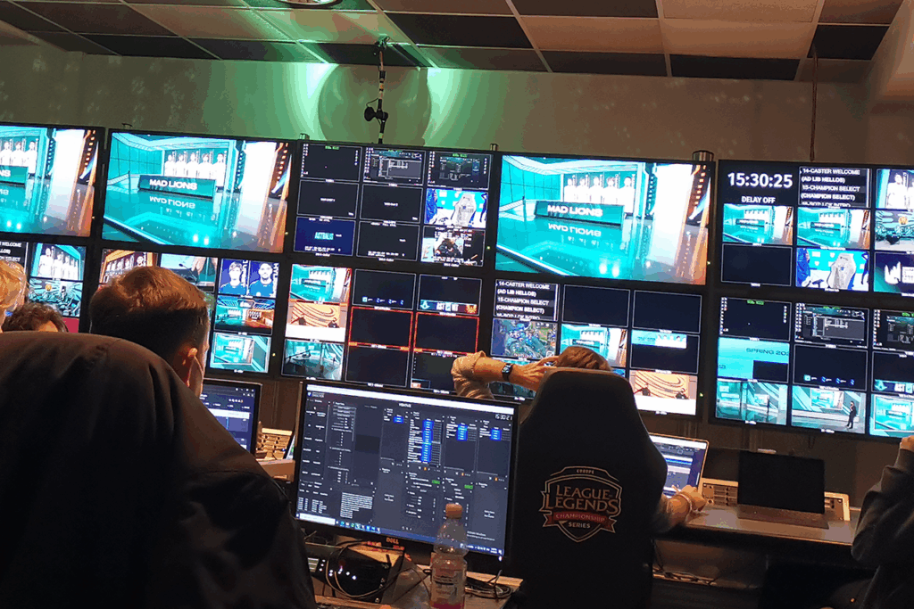 A large group of people working on the broadcast in front of a big TV during the League of Legends Show in Berlin.